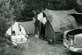 Familjen Erikssons tältsemestrar med bil på 1950- och 1960-talet. Mamma Gun-Britt håller på med hushållsbestyr vid tältet i Ljugarn på Gotlands östra sida 1959.
