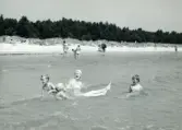 Familjen Erikssons tältsemestrar med bil på 1950- och 1960-talet. Bad i Sudersand på Fårö, Gotland 1959. På bilden mamma Gun-Britt, Thomas, Björn och Bodil.