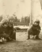 Puttekula med kompisar i gruset på gården i stadsdelen Ahlsberg i Nässjö på 1930-talet. Gun-Britt Edberg till höger i bild.