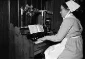 Kvinna spelar orgel, Uppsala 1947