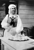 Hedvig Ulfsparre klädd i folkdräkt, serverar kaffe.