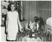 Glasdesignern Asta Strömberg, Strömbergshyttan, vid ett uppdukat bord med ljusstakar, glasbollar m.m.