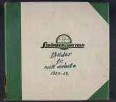 Ett fotoalbum med gråvita linnepärmar och spräcklig mörkgrön rygg och mörkgröna skoningar. 
Text på framsidan: 