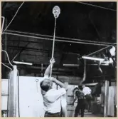 Verksamhet i hyttan på Strömbergshyttan. 
En man blåser upp ett föremål.
