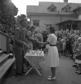 Simningen, 16/8 1942. 
Prisutdelning på Evedal. En flicka i ljus klänning får en liten 
bägare i pris.