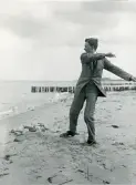 Danmark 1920. Tandläkare Gunnar Högberg kastar sten på en strand i Huleröd.