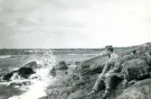 Tandläkare Gunnar Högberg sitter på en klippa vid kusten i Torekov, Skåne 1922.