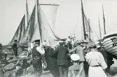 Torekov 1922. Bilden visar en hamn med förtöjda båtar och människor i rörelse, ser ut som de förmodligen skall sjösätta en båt.