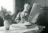 Tandläkare Gunnar Högberg sitter och läser en tidning på sin semester i Torekov, Skåne 1922.