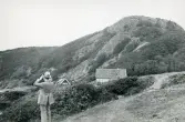Tandläkare Gunnar Högberg står och kikar utöver det dramatiska landskapet vid Kullen, Kullaberg i Skåne, 1922.