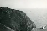 Tandläkare Gunnar Högberg ligger vid foten av en klippa och blickar ut över havet vid Kullen, Kullaberg i Skåne, 1922.