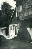 Bild av en gränd i Visby, Gotland 1927, med hus i både sten- och träkonstruktion.