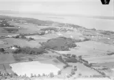 Flygbild över Gottskär. Villor och odlingslandskap med Kungsbackafjorden i bakgrunden.