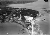 Flygbild över Gottskär. Småbåtshamn med bryggor, fritidsbåtar och restaurangbyggnaden. På vägen till Utholmen, till höger, ligger kallbadhuset.