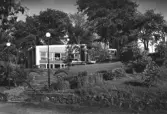 Restaurang Gröna Hästen i Laholm som nybyggd, med sitt karaktäristiska zigzagmönster upptill på fasaden. Stadsarkitekten Svend Bögh-Andersen ritade byggnaden som uppfördes 1958 i anslutning till Stadshotellet. Restaurangen ligger på en höjd, dit en stentrappa i parkmiljö leder. Förlag: Einar Lindgrens Bokhandel, Laholm.