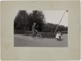 Alfred Dahlgren på cykel vinkar till barnen Agnes och Wilhelm, Uppland 1898