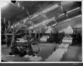 Kvarnsvedens pappersbruk, Pappersmaskin 8, byggnation del 1 och 2. Interiör bruket, pappersrullar, pappermaskin och bruksarbetare.  B718