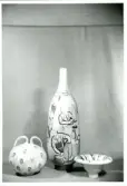 Vaser och skål från Bo Fajans, omkirng 1900-talets mitt. Den mittersta vasen dekorerad med illustrationer av olika steg inom krukmakeriet.
