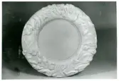 Fat med reliefkant från Bo Fajans, formgivare Maud Fredin-Fredholm, omkring 1900-talets mitt. Kanten visar människor, fiskar, däggdjur och fåglar.