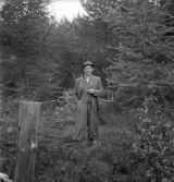 Orientering, 27/9 1942. 
En man med korg på armen i ett skogsbryn.