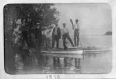 Grupp män stående på sina kajaker vid Hjälmaren, 1910