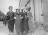 Fyra unga väninnor i armkrok på Drottninggatan, 1913