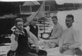 Fyra män dricker snaps på en båt, 1915