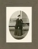 Operasångerskan Christina Nilsson poserar i promenaddräkt och hatt utanför ett av husen på Loka brunn, 1907.