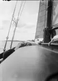 Två män ligger på en segelbåt och vilar, Uppland