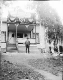 Man står framför ett bostadshus, Uppland