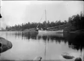 Tre män sitter i en segelbåt och metar, Uppland