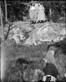 Man och kvinnor står på en sten, Uppland