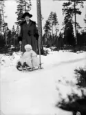 Inez Hällbom med ett litet barn på kälke, Uppsala, Uppland