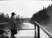 Inez Hällbom står och tittar på forsande vatten, Sverige