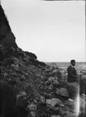 Enok Hällbom sitter på en sten och tittar ut över havet, Gotland