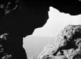 Enok Hällbom sitter på en klippa och och röker pipa, Gotland