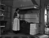 Inez Hällbom står vid spisen och lagar mat, Uppsala , Uppland