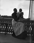 Kvinna med ett litet barn stående i knät, Uppsala, Uppland