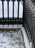 Gamla kyrkogården i Gävle, renovering av gravstaket med tillhörande stensocklar, etapp 2025. Gravvård GK07 0116 efter åtgärd. Marken ska fyllas på så att kramlingen döljs.