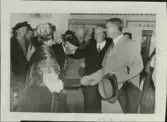 Skansen. Byggnader. Delsbogården.   Invigningen den 18 augusti 1940. Kronprinsen hälsar i Västerängsstugan på hälsingebonden Elof Jonsson och hans maka. Det var Jonssons far som genom konstnären Bror Hillgrens förmedling 1928 sålde stugan till Nordiska museet.