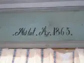 Interiör från stugan i parstugan på Nygårdsgården i Bingsjö. Byggnaden stod ursprungligen på annan plats i byn men flyttades omkring 1860–1861 till nuvarande plats som då var åkermark.

Datering av måleriet i rummet: 