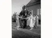Personal dansar runt midsommarstången vid barnhemmet Vita Bandet i Varberg.