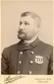 Porträtt av troligen en uniformerad polis eller tjänsteman.