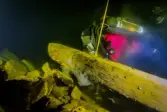 Marinarkeolog sågar en tvärgående balk