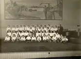 Hvitfeldtsskolan (Hvitfeldtska) uppfördes åren 1915-1919 och arkitekt var Ernst Torulf.
Lärare Ewald Dahlström med kör samlad i Hvitfeldtsskolans aula. I fonden konstnären Carl Wilhelmssons målning 