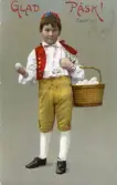 Påskkort med motiv av pojke i folkdräkt med en korg fylld med ägg. Adresserat Ellen Sundberg.