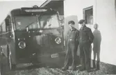 Två män står bredvid en buss från Kållereds bussbolag, troligtvis Kållered centrum, 1930-tal. Från vänster: chaufför John Johansson, Nygård, samt en okänd man. Bussarna gick på linjen Göteborg-Anderstorp-Hällingsjö.