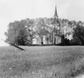 Kyrka med träd omkring.


