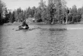 Fångsjön. Virket skjuts in innanför länsen. Reidar Ragnarsson sitter på stammen och Göran Roos ror.