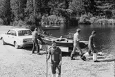 Fångsjön. Båtarna ska transporteras på bilsläp ner till Sporrsjön. Reidar Ragnarsson, Johan Wikström, Henrik Boman och Bernard Isaksson har just lyft upp båten på släpet. 